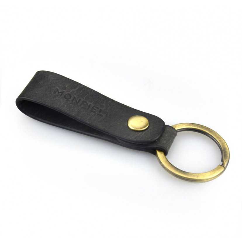 Black unisex leather keychain with logo detail, slightly tilted on a white background - MONPIEL