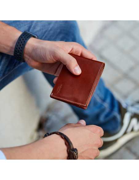 Portefeuille homme en cuir couleur havane, photo en extérieur prise sur un fond au sol - MONPIEL Portefeuille homme en cuir couleur havane, photo en extérieur prise sur un fond au sol - MONPIEL
