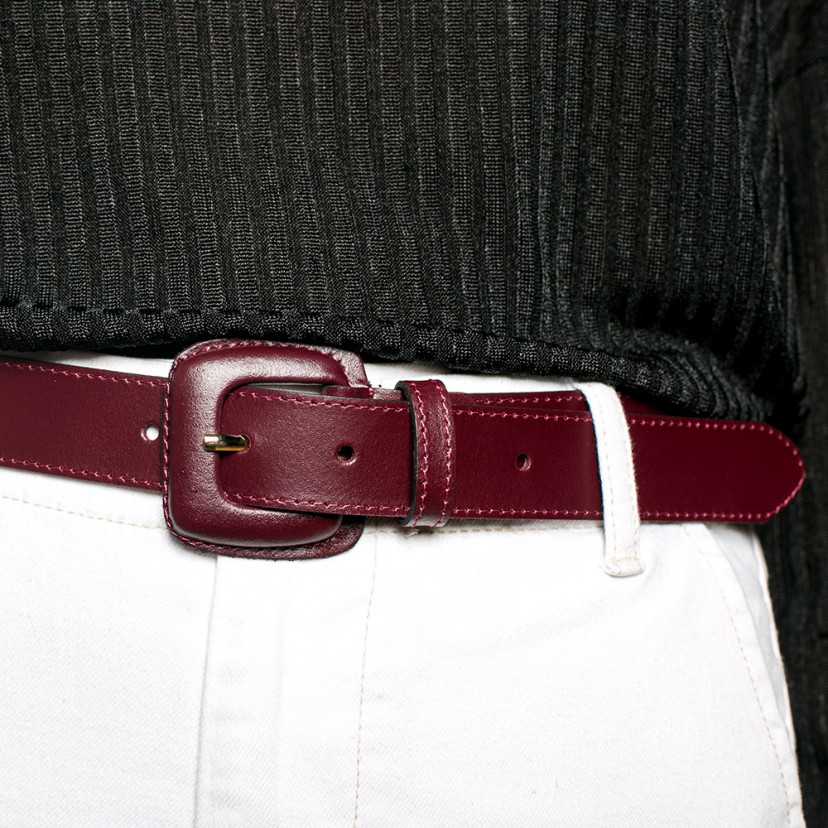 Cinto feminino de couro bordô com fivela revestida, usado na cintura sobre calça branca - MONPIEL