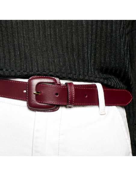 Women’s burgundy leather belt with covered buckle, worn at the waist over white pants - MONPIEL Women’s burgundy leather belt with covered buckle, worn at the waist over white pants - MONPIEL