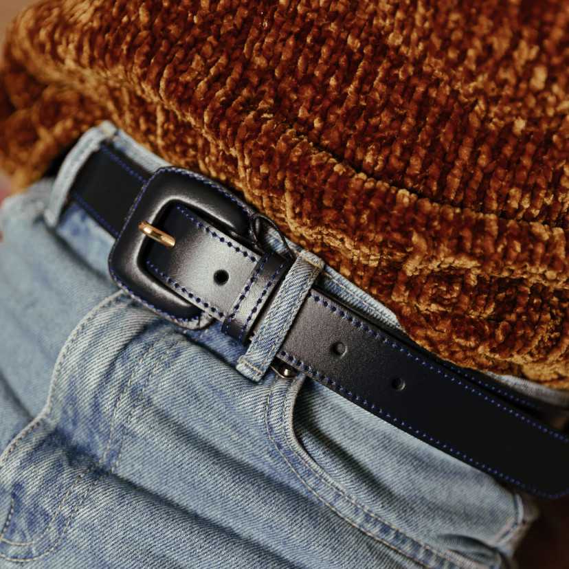 Women’s navy leather belt with covered buckle, worn at the waist over jeans - MONPIEL