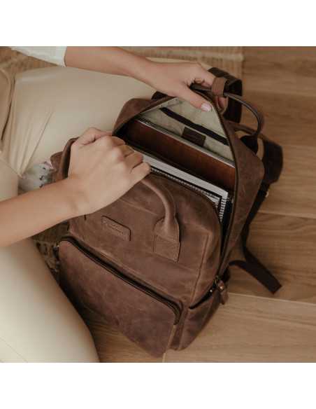 Mochila de couro marrom sendo aberta no chão, com detalhe interno - MONPIEL Mochila de couro marrom sendo aberta no chão, com detalhe interno - MONPIEL