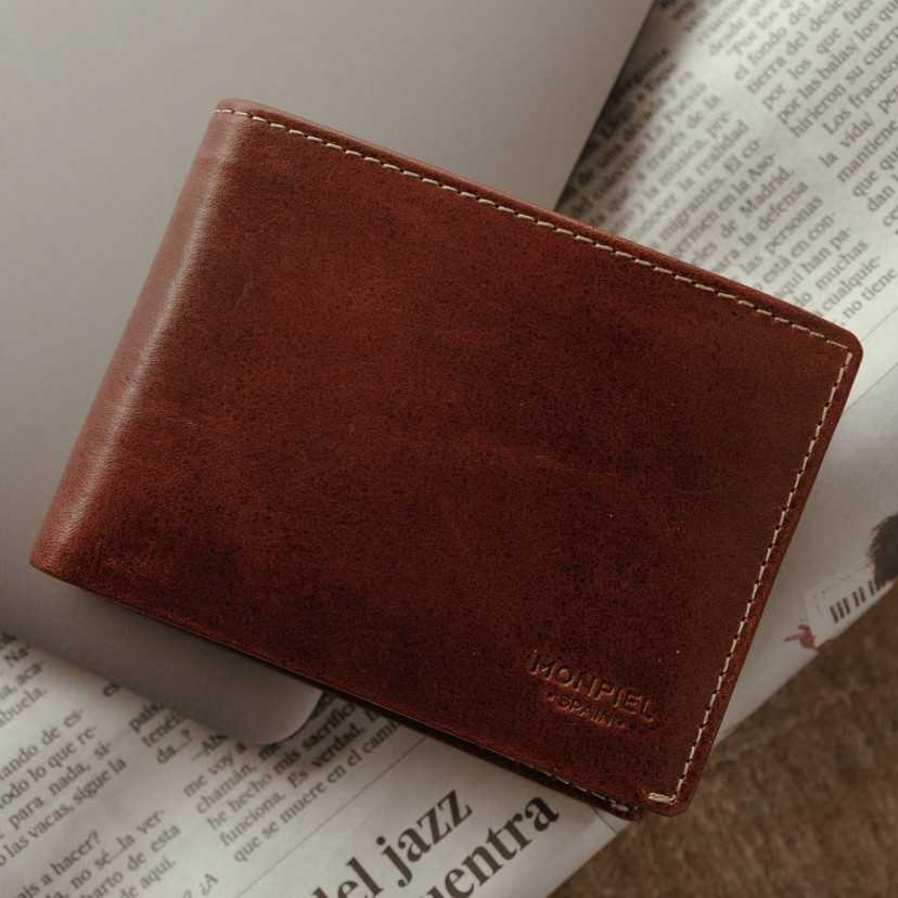 Havana leather wallet for men, front view, resting on a laptop and newspaper - MONPIEL