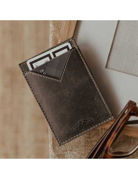 Porte-cartes pour homme en cuir bleu, légèrement incliné, appuyé contre un cadre photo - MONPIEL