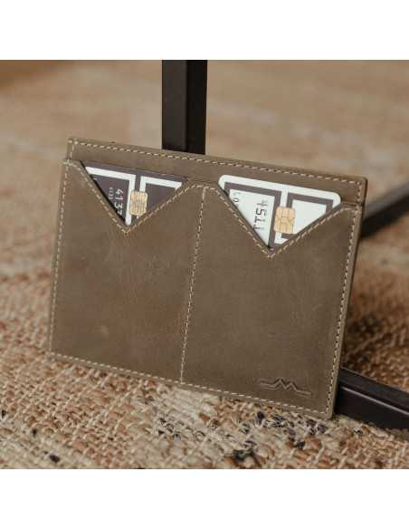 Men’s green leather passport holder with card slots, resting on a table - MONPIEL Men’s green leather passport holder with card slots, resting on a table - MONPIEL