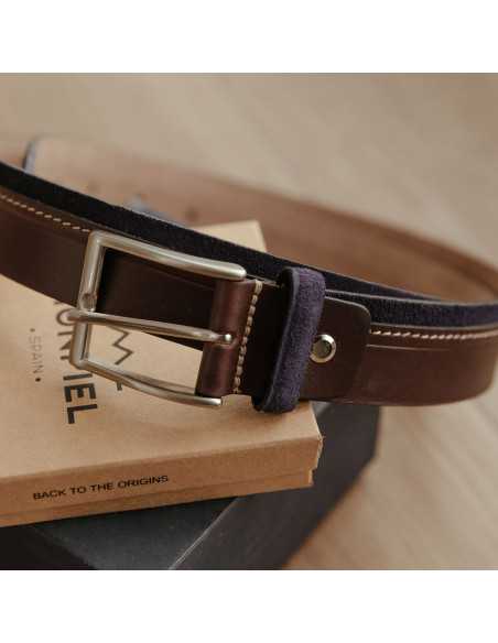 Ceinture en cuir vaquetilla et suède de couleur bleu marine posée sur des boîtes, avec détail focalisé sur la boucle - MONPIEL