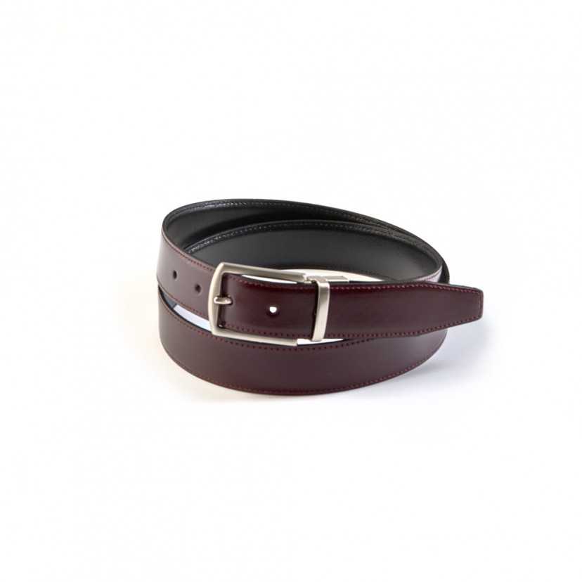 Black-burgundy leather belt with metal buckle, coiled, on a white background - MONPIEL