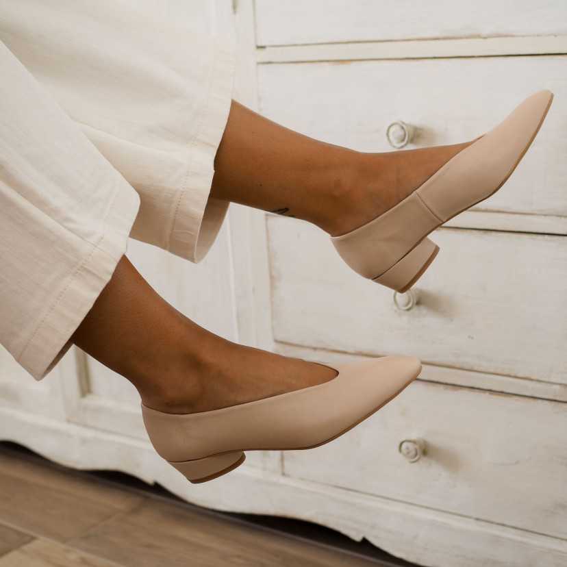 Beige heeled ballet flat, loose feet detail, side view with furniture background - MONPIEL