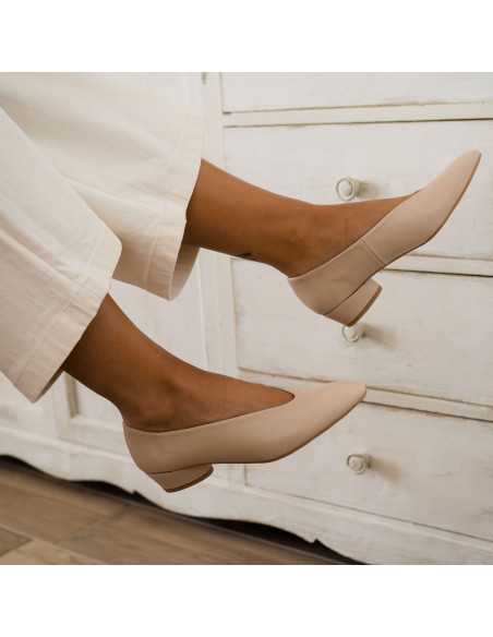 Beige heeled ballerina shoes, detail of feet free, side view with furniture background - MONPIEL