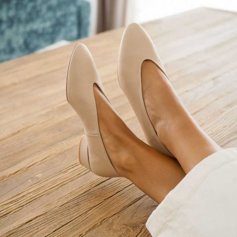 Beige heeled ballet flat, crossed feet detail on a table, perspective view - MONPIEL