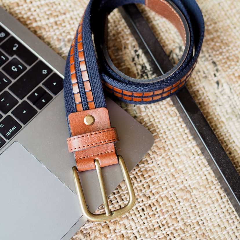 Men’s navy canvas and leather belt, coiled, on a laptop - MONPIEL