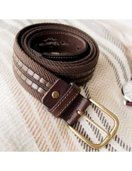 Herren-Gürtel aus braunem Leinen und Leder, auf einer Decke aufgerollt, mit Fokus auf die Schnalle - MONPIEL Herren-Gürtel aus braunem Leinen und Leder, auf einer Decke aufgerollt, mit Fokus auf die Schnalle - MONPIEL