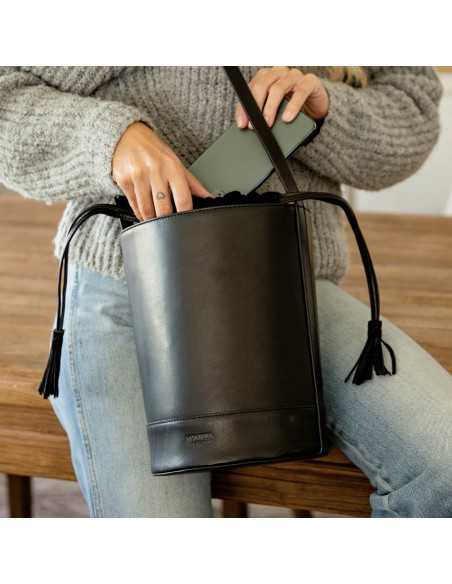 Runde Tasche in Schwarz, Vorderansicht beim Einlegen eines Handys - MONPIEL