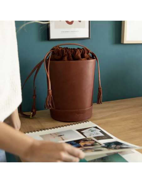 Sac rond en forme de seau en cuir havane, vue de face devant un mur - MONPIEL