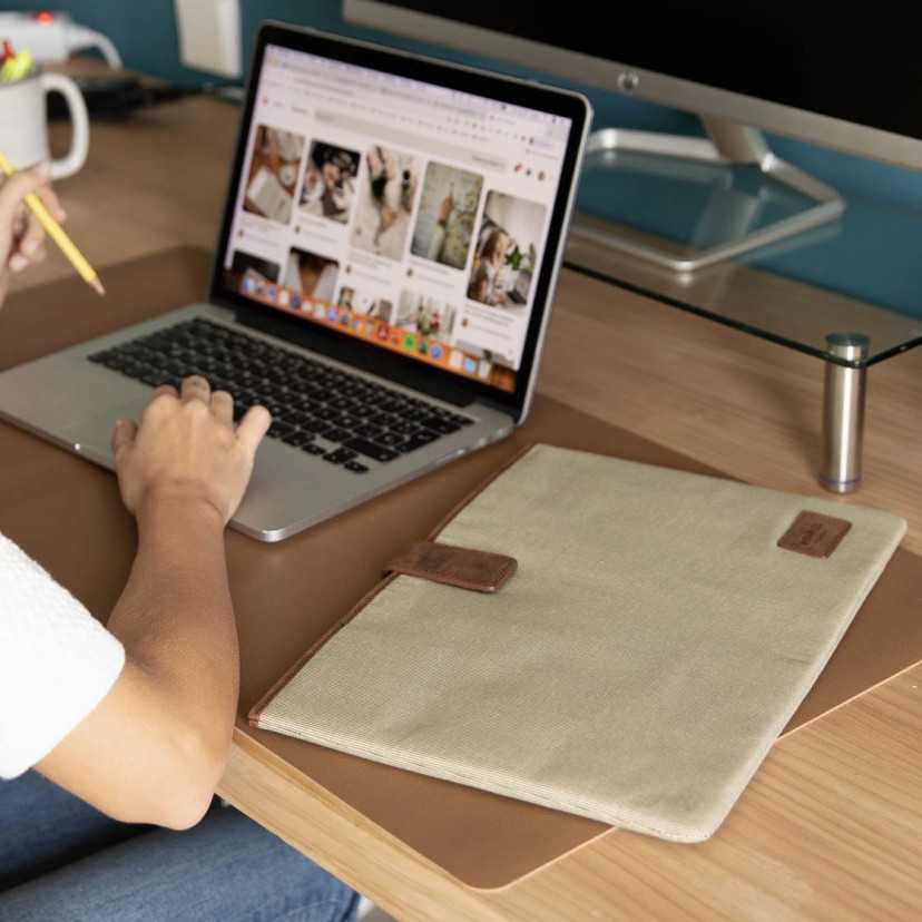 Capa para notebook de 15" polegadas na cor bege sobre a mesa com o notebook ao lado - MONPIEL