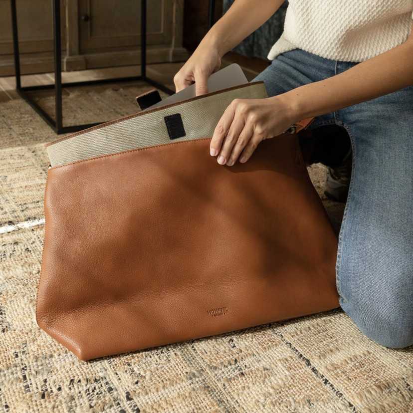 Capa para notebook de 15" polegadas na cor bege sendo guardada na bolsa - MONPIEL