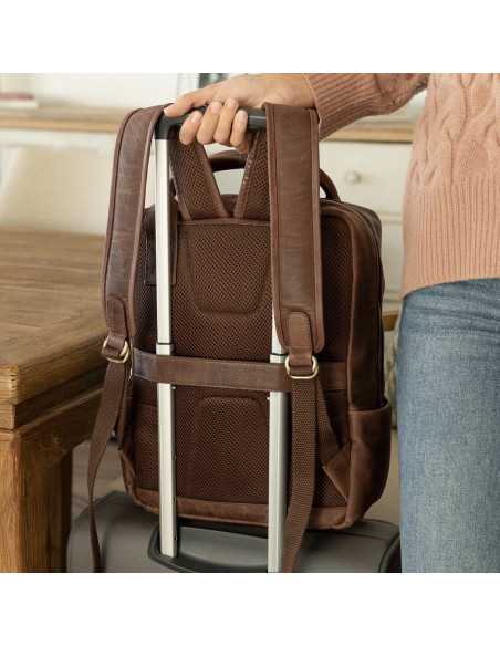 Mochila de couro marrom com vista traseira apoiada em uma mala - MONPIEL Mochila de couro marrom com vista traseira apoiada em uma mala - MONPIEL