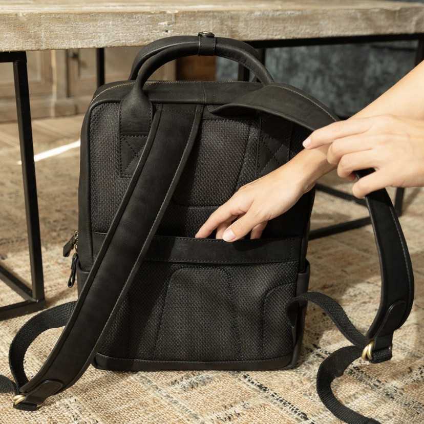Black leather backpack, rear view, resting on a rug - MONPIEL