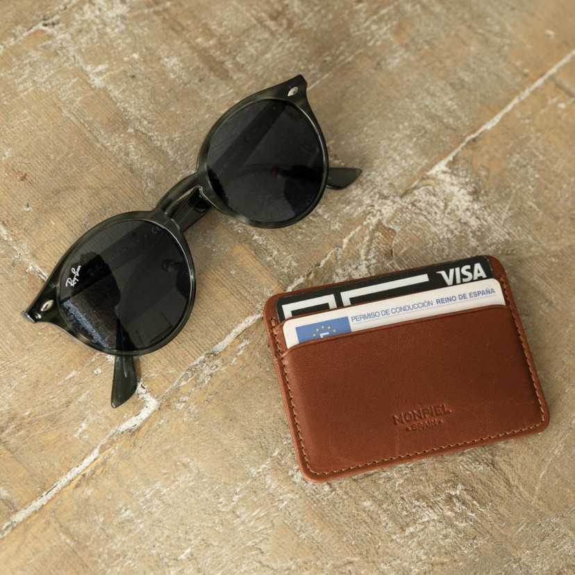 Mini Havana leather cardholder, front view, with glasses next to it on the floor - MONPIEL
