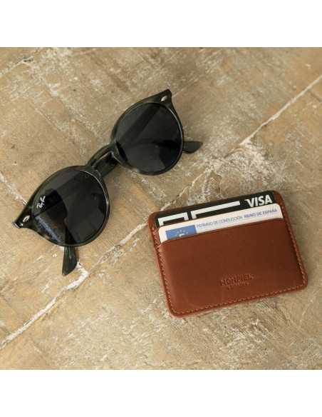 Mini Havana leather cardholder, front view, with glasses next to it on the floor - MONPIEL Mini Havana leather cardholder, front view, with glasses next to it on the floor - MONPIEL
