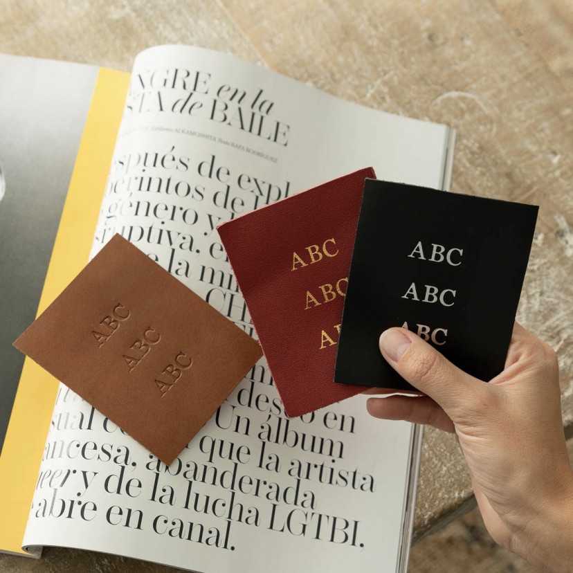 Three custom initials engraved in hot-stamp, gold, and nickel, set against a magazine background - MONPIEL