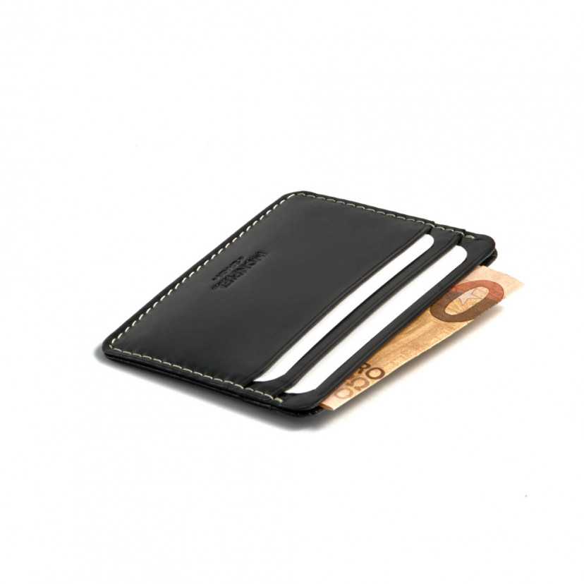 Mini leather cardholder in black, perspective view with bill detail on a white background - MONPIEL