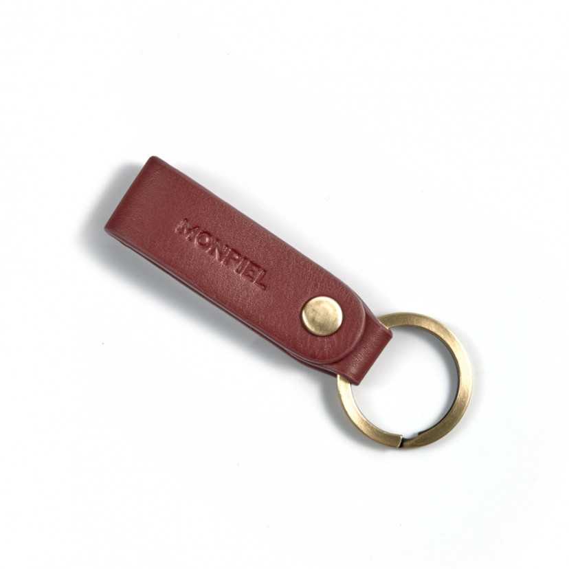 Burgundy and tan leather pocket keychain, closed and tilted on a white background - MONPIEL
