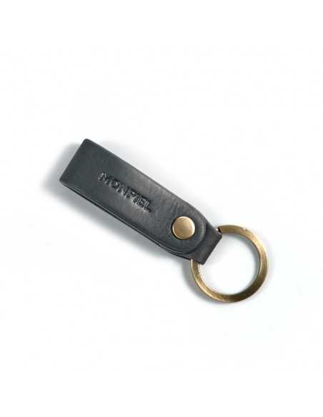 Blue leather keychain, closed and slightly tilted with logo detail on a white background - MONPIEL Blue leather keychain, closed and slightly tilted with logo detail on a white background - MONPIEL