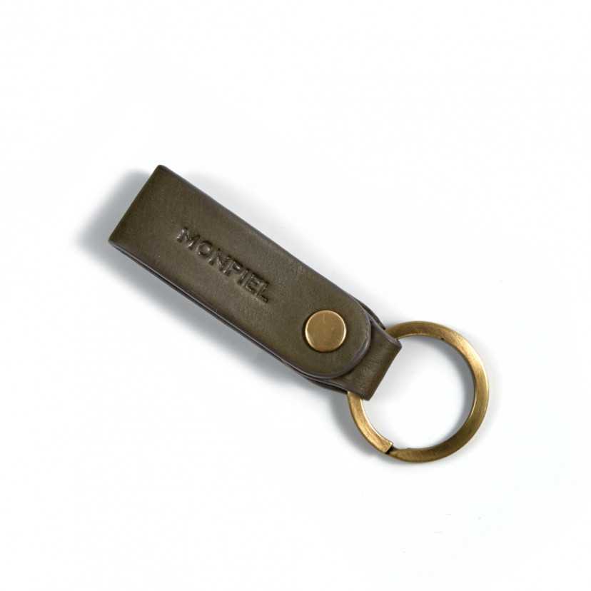 Green unisex leather keychain, closed and slightly tilted on a white background - MONPIEL