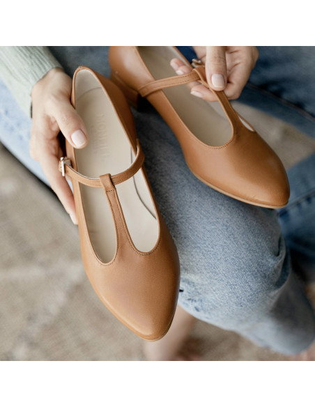 Women's Marieta leather Mary Janes in tan, shown from above held with hands on jeans - MONPIEL Women's Marieta leather Mary Janes in tan, shown from above held with hands on jeans - MONPIEL