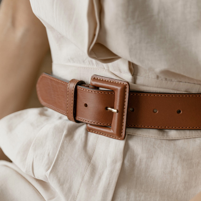 Wide women's leather belt with covered buckle in tan, close-up with focus on the buckle - MONPIEL
