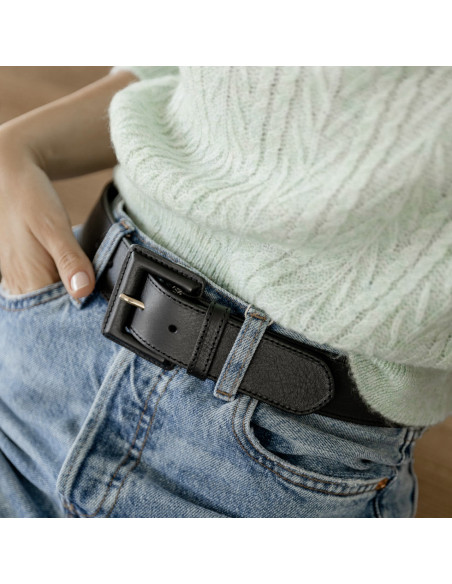 Cintura larga da donna in pelle con fibbia rivestita in pelle nera, indossata su jeans con messa a fuoco sulla fibbia - MONPIEL Cintura larga da donna in pelle con fibbia rivestita in pelle nera, indossata su jeans con messa a fuoco sulla fibbia - MONPIEL