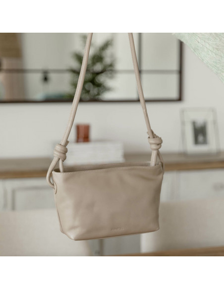Bolsa pequena de couro com nós na cor taupe com vista frontal segurada pela alça - MONPIEL