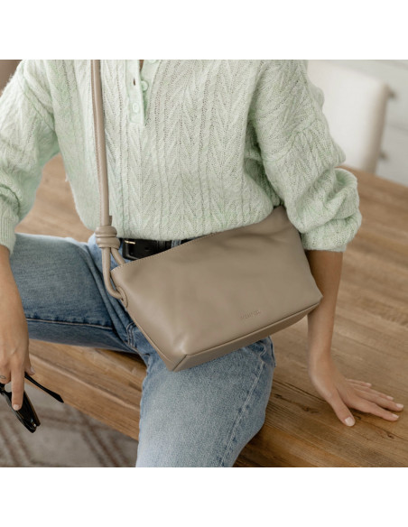 Bolsa pequena de couro com nós na cor taupe, pendurada na transversal, sentada sobre a mesa - MONPIEL
