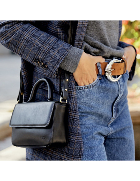 Bolsa de couro pequena Armado na cor preta, pendurada no ombro com plano em detalhe, fundo externo - MONPIEL Bolsa de couro pequena Armado na cor preta, pendurada no ombro com plano em detalhe, fundo externo - MONPIEL