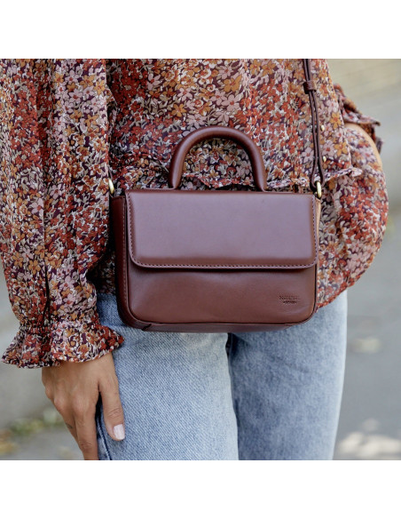 Small Armado leather bag in brown, shown from the front, worn crossbody - MONPIEL Small Armado leather bag in brown, shown from the front, worn crossbody - MONPIEL