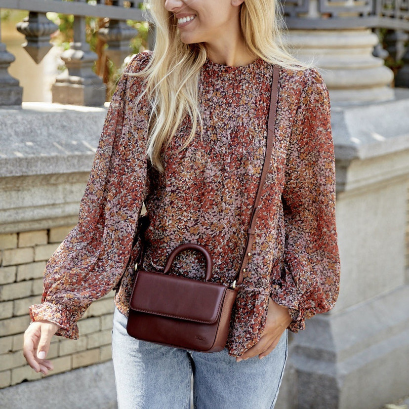 Small Armado leather bag in brown, worn crossbody, mid-shot outdoors - MONPIEL