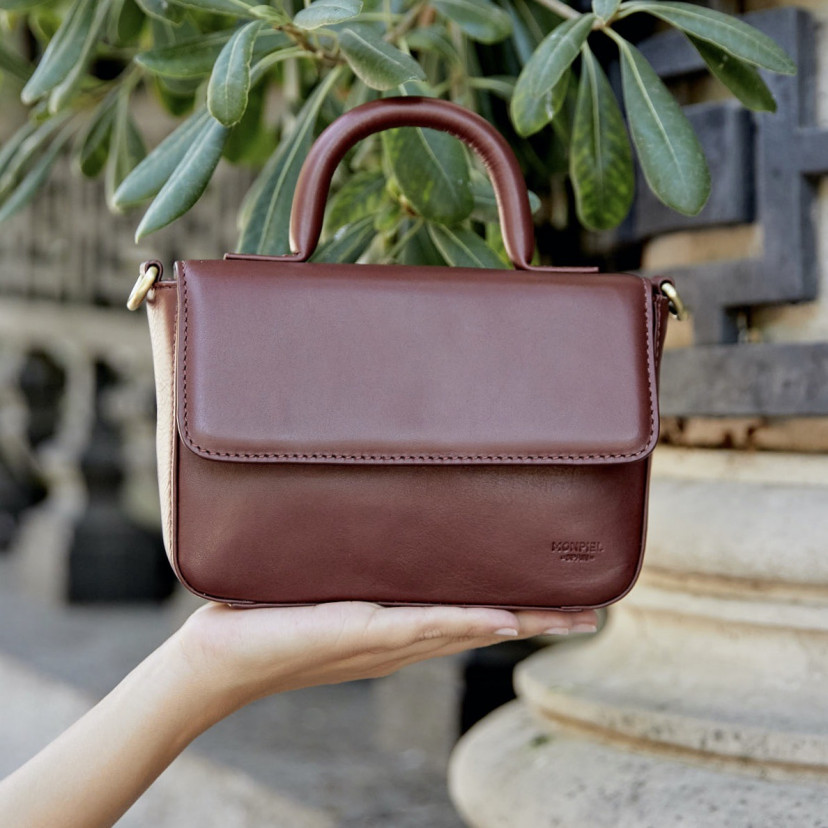 Bolsa de couro pequena Armado na cor marrom com vista frontal apoiada sobre a mão em primeiro plano - MONPIEL