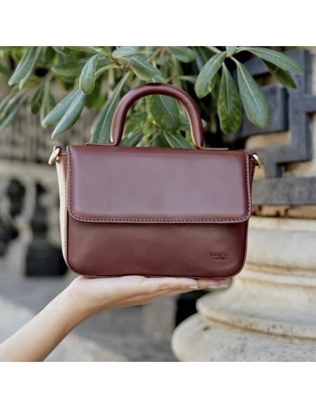 Small Armado leather bag in brown, shown from the front, resting on the hand in close-up - MONPIEL Small Armado leather bag in brown, shown from the front, resting on the hand in close-up - MONPIEL