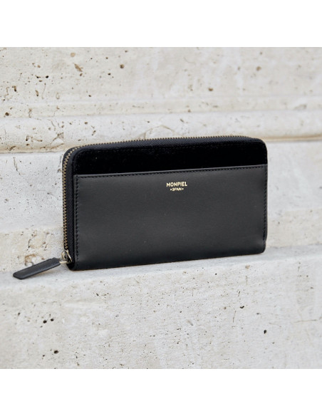 Portafoglio donna in pelle con cerniera color nero, vista frontale su un muro - MONPIEL