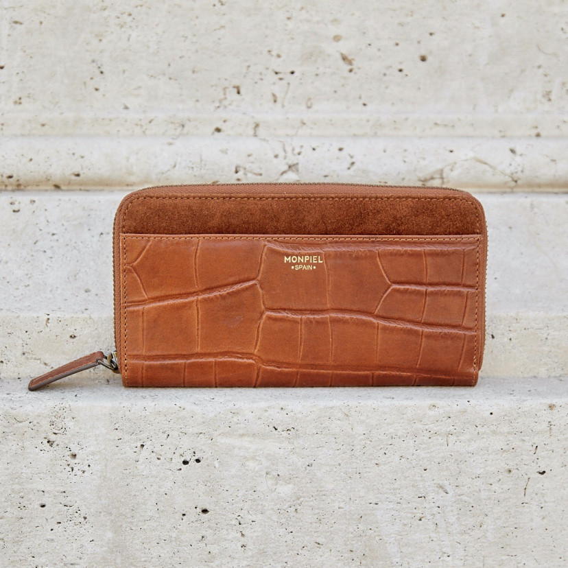 Women's leather zipper wallet in tan, shown from the front against a wall - MONPIEL