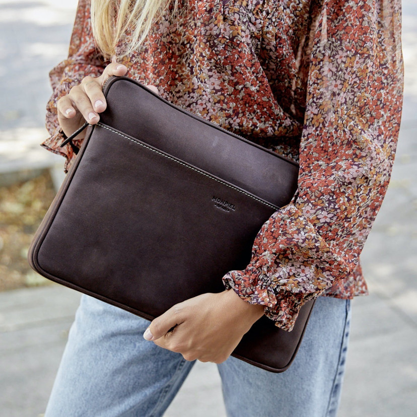 13" and 14"-inch leather laptop sleeve in brown, held by hand with an outdoor background - MONPIEL
