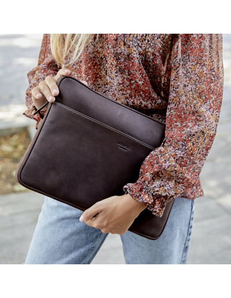 Capa para laptop de couro de 15" polegadas na cor marrom, segurada pela mão com fundo externo - MONPIEL