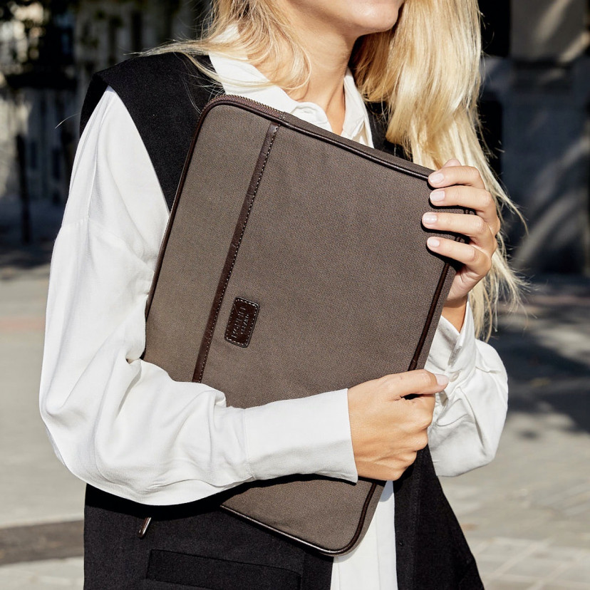 13" and 14"-inch green leather sport laptop sleeve, held by hands with an outdoor background - MONPIEL