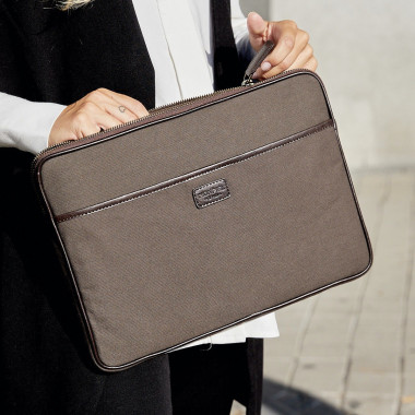 13" and 14"-inch green leather sport laptop sleeve, held by hands with an outdoor background - MONPIEL 2