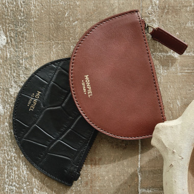 Leder-Münzgeldbörse in Halbmondform in Lederfarbe, gehalten in den Händen mit Außenhintergrund - MONPIEL 2