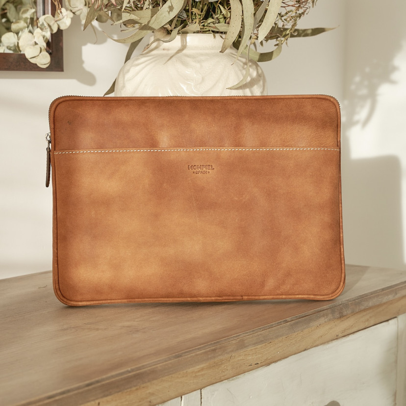 13" and 14"-inch leather laptop sleeve in tan, shown from the front resting on a vase - MONPIEL