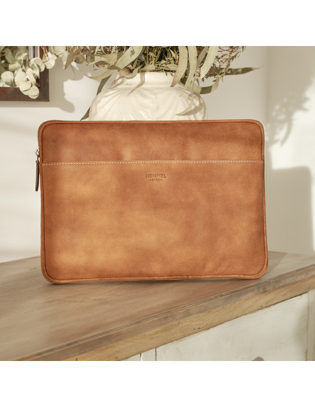 13" and 14"-inch leather laptop sleeve in tan, shown from the front resting on a vase - MONPIEL