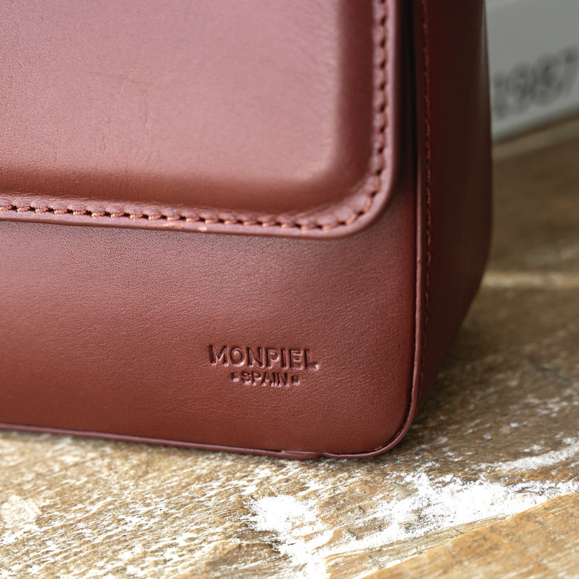 Small Armado leather bag in brown, with logo detail in close-up focus - MONPIEL