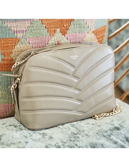 Sac en cuir matelassé avec chaîne dorée taupe, vue de face reposant sur un coussin - MONPIEL